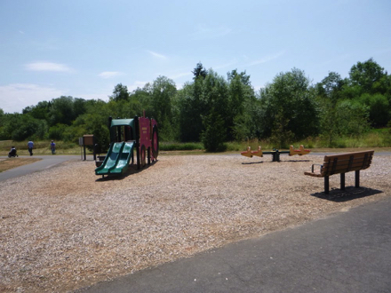 Playground with bark chip surface along paved trail